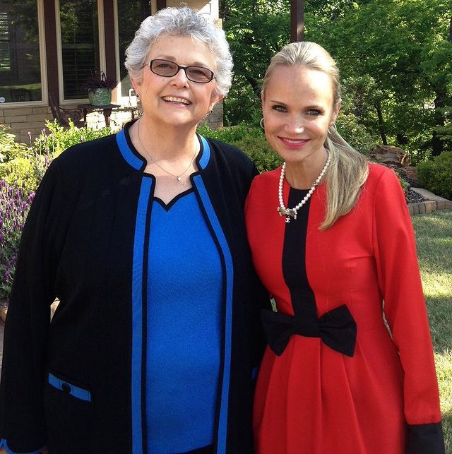Junie Chenoweth smiling in a black and blue dress with her daughter Kristin Chenoweth.
